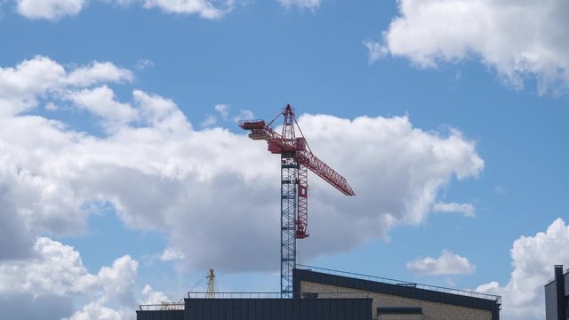 Timelapse with working construction cranes building houses on sky background.