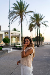Chica joven y guapa junto a palmeras de compras