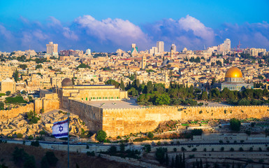 Fototapeta na wymiar Beautiful sunlit view of Jerusalem: the Temple Mount with Dome of the Rock and Al Aqsa Mosque, archaeological park of the Southern Wall and Huldah Gates; with Israeli flag in the foreground and clouds