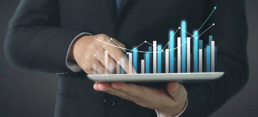  Plan graph growth and increase of chart positive indicators, tablet in hand