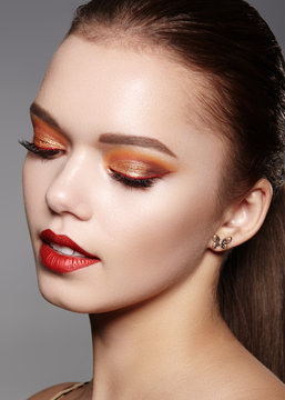 Closeup portrait of Woman Face with Gold glitter Make-up, bright red liner on Eyes. Fashion Celebrate Makeup, Glowy Skin