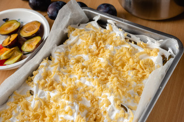 Plum cake ready for baking. Homemade shortcrust pastry with purple plums.
