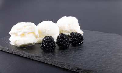 Ripe blackberries and white ice cream.