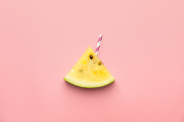 Cut yellow watermelon with straw on color background