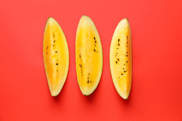 Cut yellow watermelon on color background