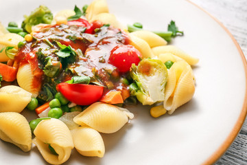 Plate with tasty conchiglie pasta and vegetables, closeup