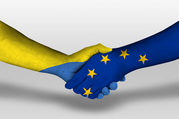 Handshake between european union and ukraine flags painted on hands, illustration with clipping path.