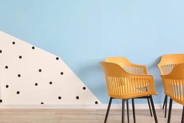 Modern chairs near color wall