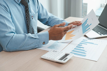 businessmen are checking company graphs to compare last year's profits with this year to plan business for the future.