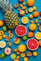 Flat lay layout of summer and citrus fruits on blue background