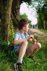 boy sitting on  tree under a tree, park rest concept