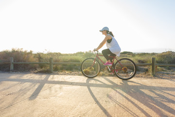Woman riding a bike on a sunny day.