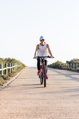 Woman riding a bike on a sunny day.