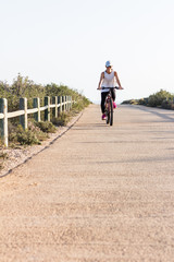 Obraz premium Woman riding a bike on a sunny day.