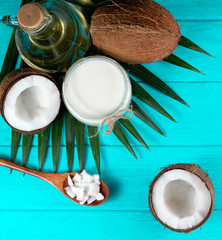 Coconut with coconut oil  on green wooden background. Healthy food concept