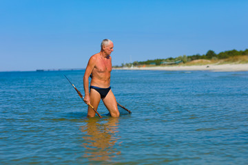 Man with a homemade spear in the sea.