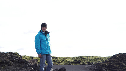 Naklejka premium Asian man jiking in Iceland wearing blue outdoor jacket in Summer