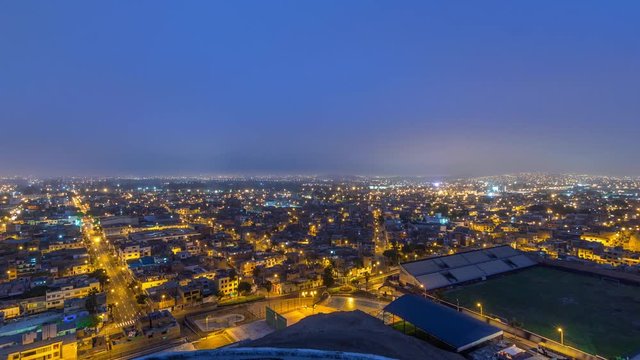 Panoramic skyline of Lima city from above with many buildings aerial night to day transition timelapse from hill. Poor houses with hills on a background. Traffic on streets. Lima, Peru