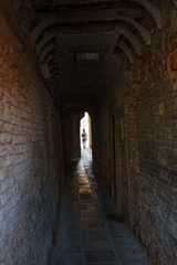 someone walking into a narrow Venetian alley