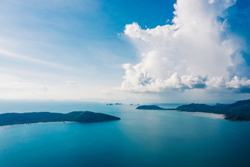 Bird's eye view of picturesque uninhabited islands surrounded by pure nature. Beautiful blue sky with white clouds. Breathtaking scenery landscape with sea