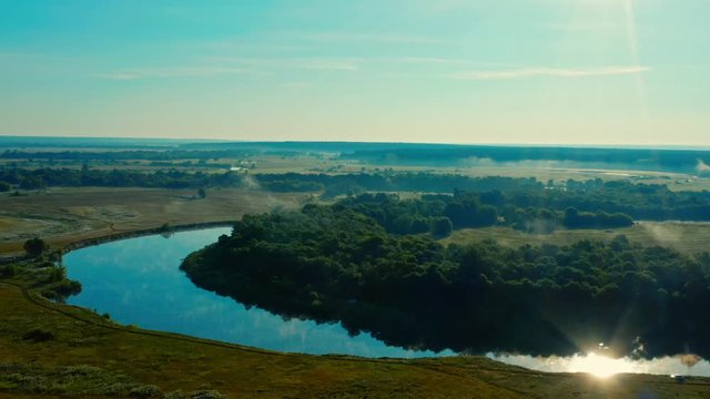 Aerial view of sunrise with a blue sky above river Desna, Ukraine. Drone flies forwards above beautiful morning landscape with a fog while  sunrise. Drone flies over tranquil summer landscape.