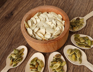 pumpkin seeds in a wooden plate on a wooden table