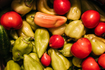 Paprika and tomatoes close-up. Yellow and green bell peppers and red tomatoes. Delicious and healthy fresh vegetables, top view.