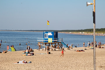 Palanga. Resort on the shores of the Baltic Sea. Large sandy beach. Sunny warm day. Many people are relaxing on the beach. Summer 2020. After quarantine. Sun and water. Rest at the sea. Sunbathing