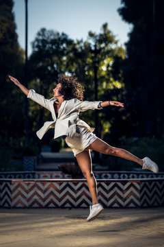 curly hair young woman dancing in a park contemporary dance