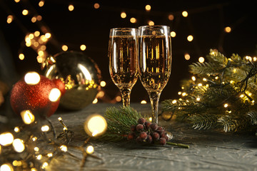 Ribbon, baubles and wine against Christmas lights.