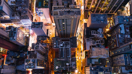 Aerial top view of downtown district  buildings in night city light. Bird's eye view from drone of cityscape metropolis infrastructure, crossing streets with parked cars. Development infrastructure