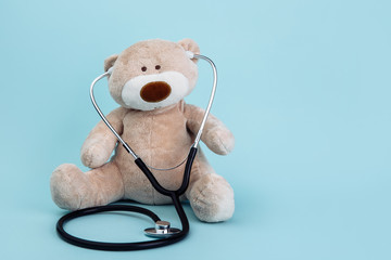 Pediatrician concept. Stuffed Bear animal presented as a pediatrician holding a stethoscope with copy space .