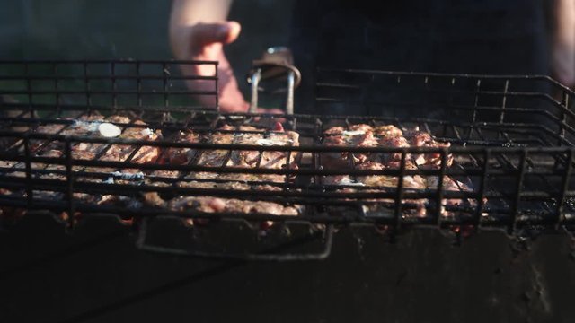 Person Flipping Burger Patties on Grill.