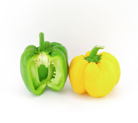 Yellow and green bell peppers cut into pieces, placed on white.