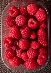Transparent plastic container full of fresh red rasberries in Helsinki, Finland