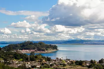 Foto op Canvas Massive clouds sweep through blue skies over the San Rafael Bay section of San Francisco Bay with neighborhoods, rock quarry and calm blue waters  Royalty free stock photo © seacave