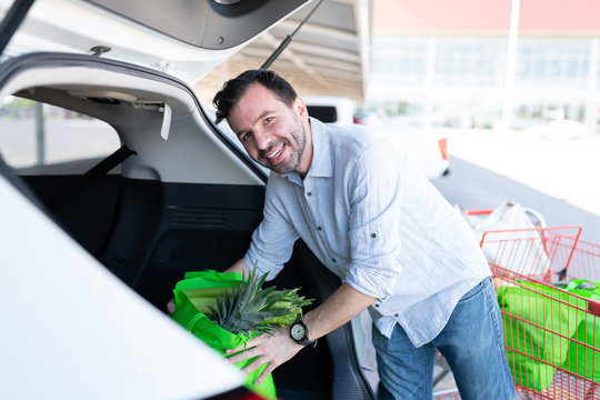 Good Looking Man Loading Grocery Bag In Car