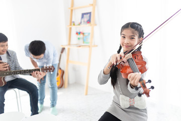 cute asian children holding violin on her shoulder and play violin, she show violin skill and...
