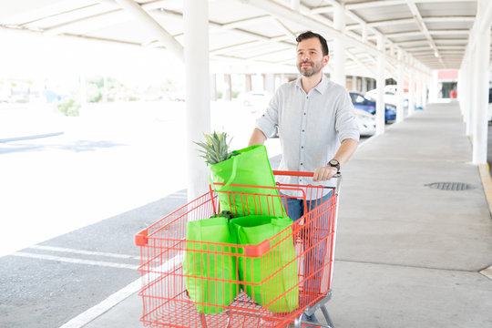 Man Looking Away While Pushing Shopping Cart