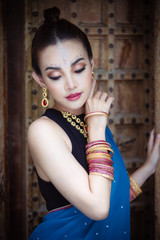 Portrait of young asian girl with kundan jewelry set and traditional hindu Indian costume saree and lehenga dress model