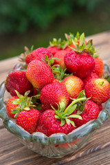 Strawberries in a crystal vase on a wooden table