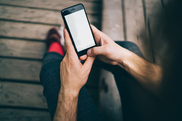 Faceless man using mobile phone on street