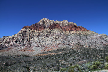 red rock layered rock mountain in desert