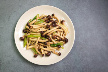 Yanagi Mutsutake (Japanese mushroom) stir-fried with oyster sauce isolated on grey table background. Healthy meal.