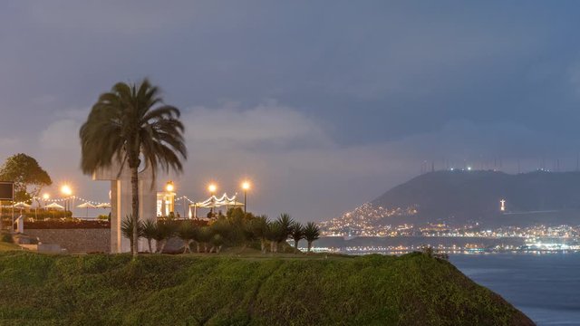 Intihuatana park with panoramic view of Miraflores district and Morro Solar hill on a background day to night timelapse, in Lima, Peru. Palm and caffee with illuminated street lights