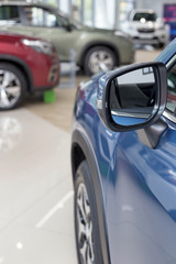 New modern cars at dealer showroom. Themed blur background with bokeh effect. Car auto dealership.