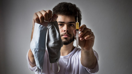portrait of a young man with a syringe for vaccination covid