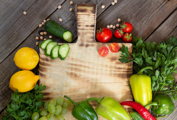 Fresh eco vegetables for cooking around wooden cutting board from above