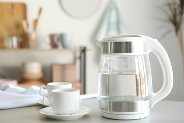 Pure water boils in an electric kettle on the table in the kitchen
