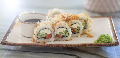 Japanese sushi rolls set with wasabi, ginger and soy sauce served on traditional plate